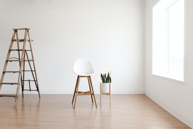 empty-room-with-chair-and-ladder-with-white-walls-and-wooden-flooring